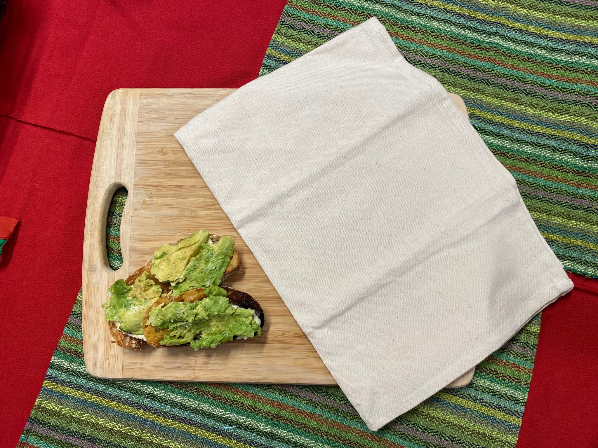 Natural coloured eco tea towel displayed on chopping board with avocado toast