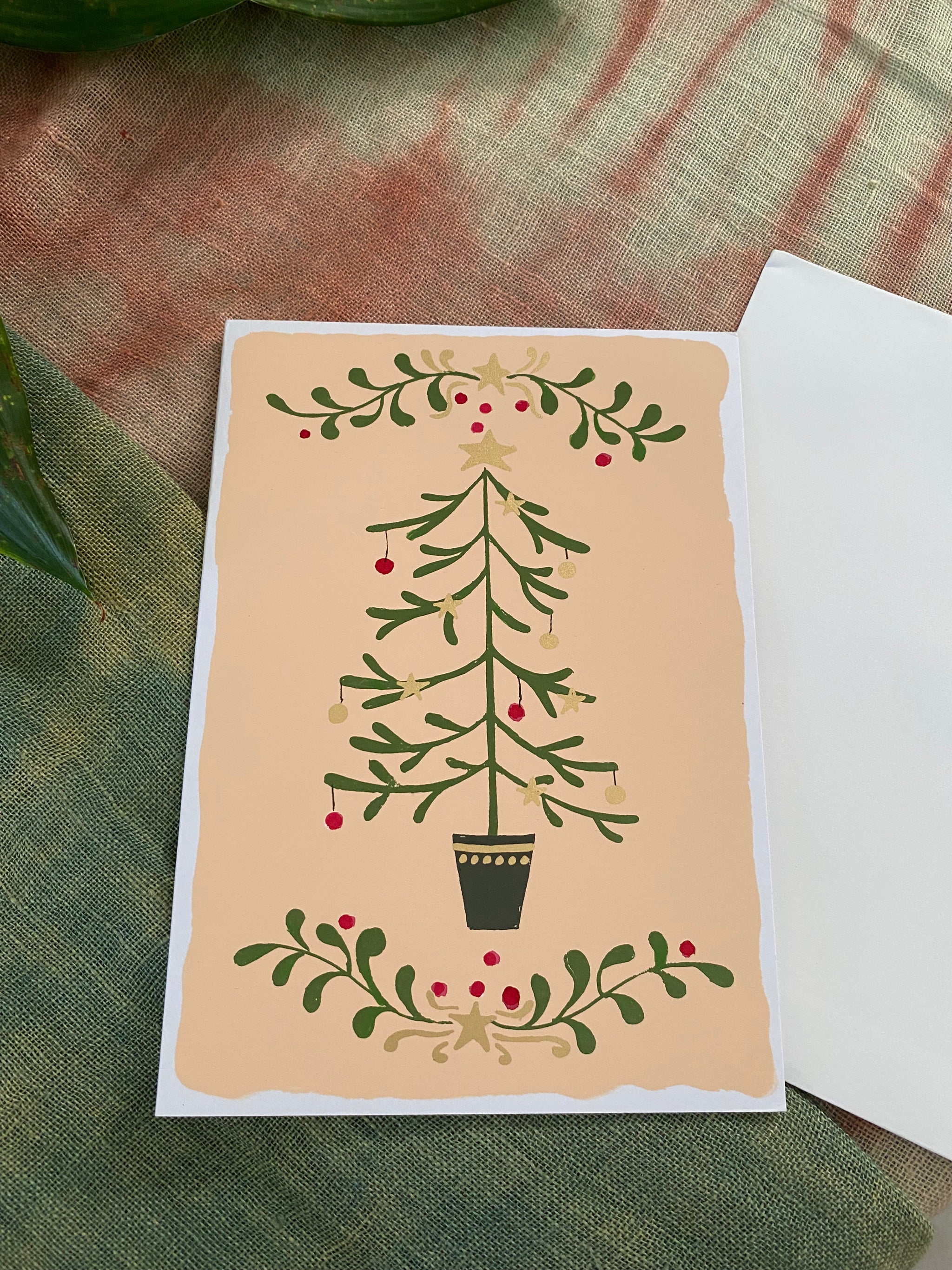 Greeting card with a Christmas tree design on a textured fabric background