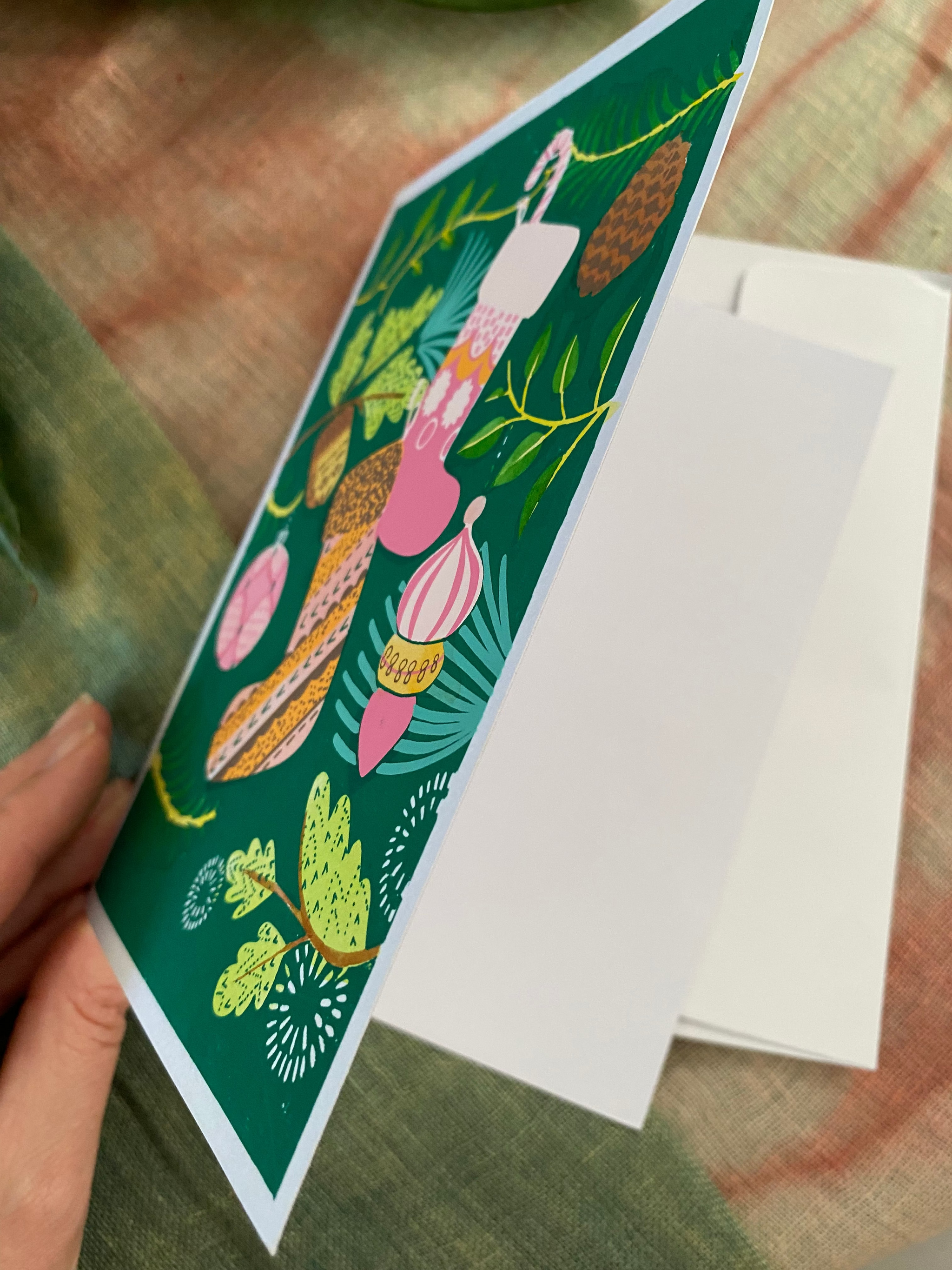 Decorative card with nature-themed design on a white envelope
