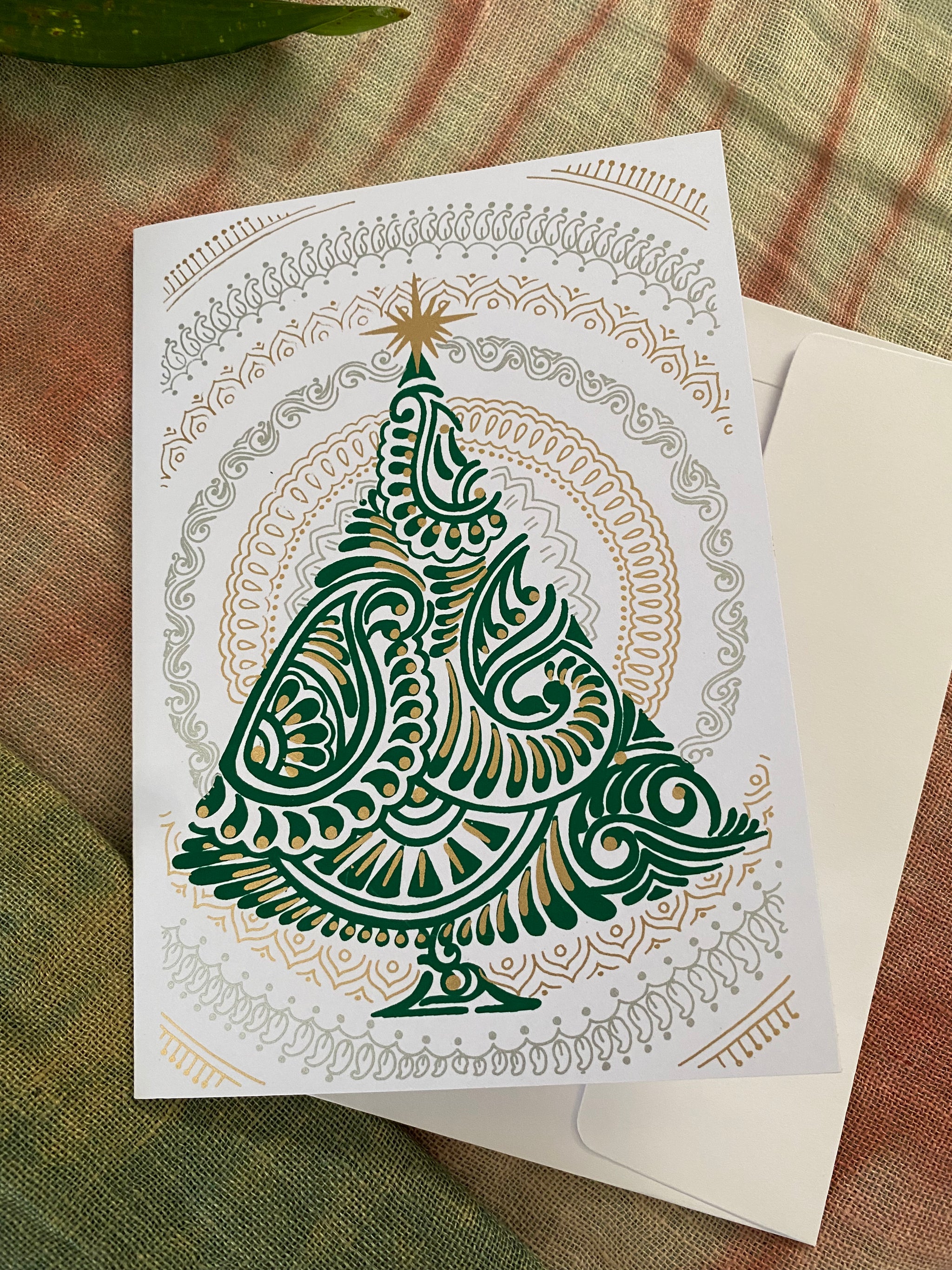 Greeting card with a decorative Christmas tree design on a textured surface