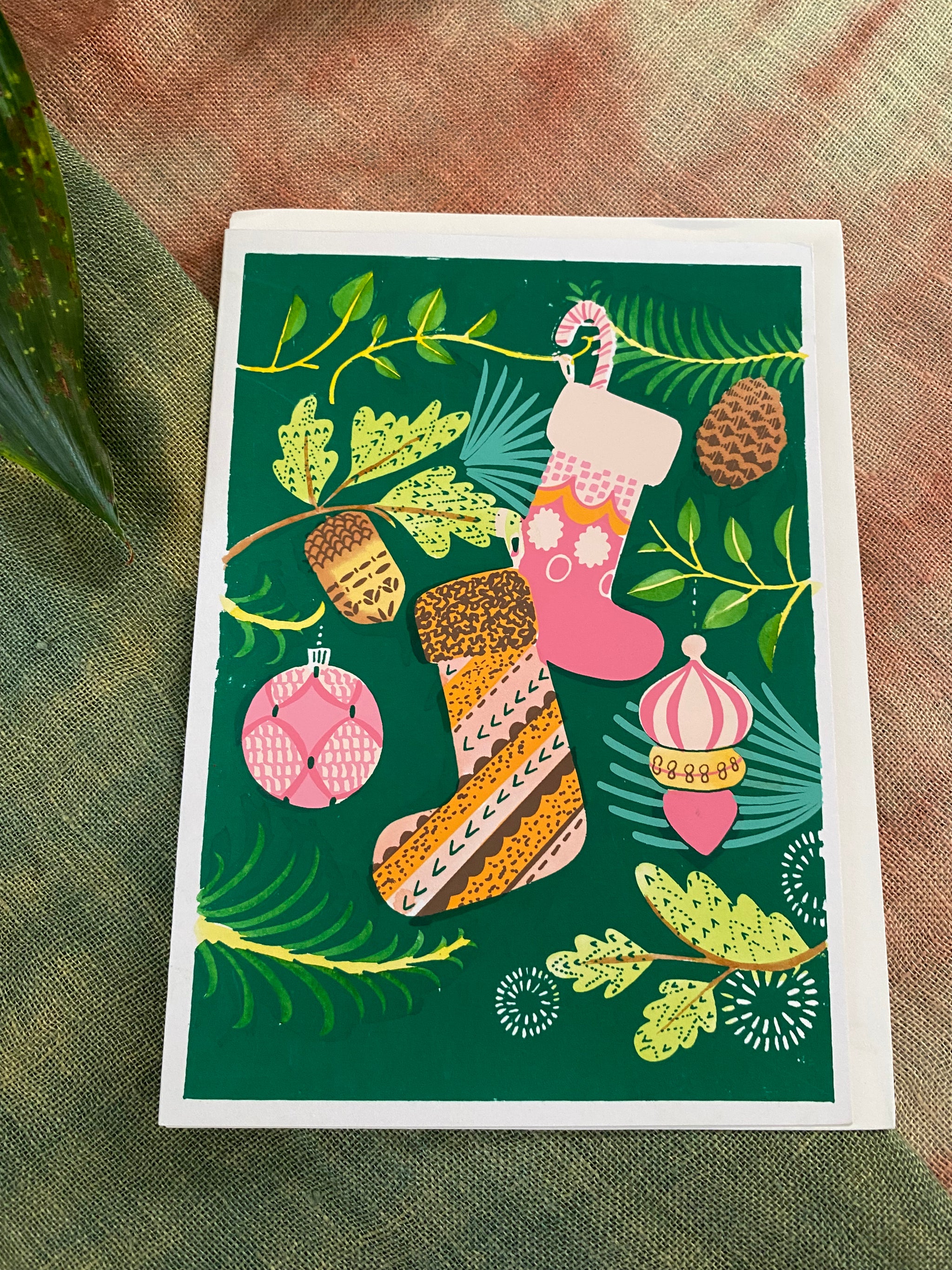 Greeting card with Christmas stockings and ornaments on a green background