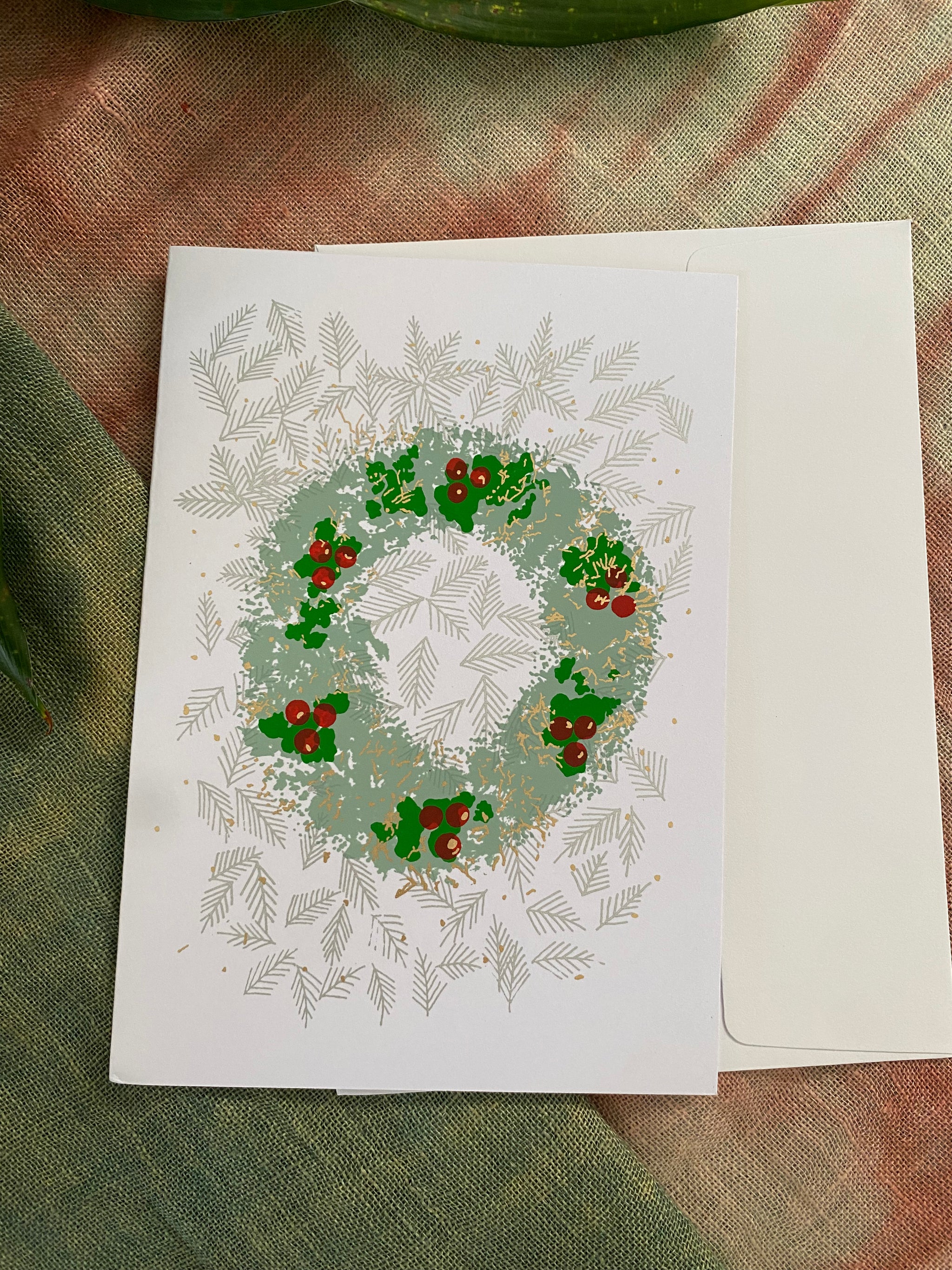 Greeting card with a Christmas wreath design on a textured fabric background