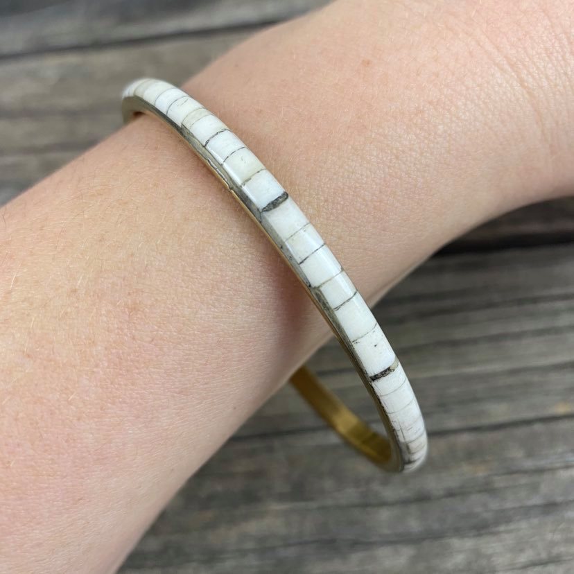 Detail of white resin and metal bangle on models arm