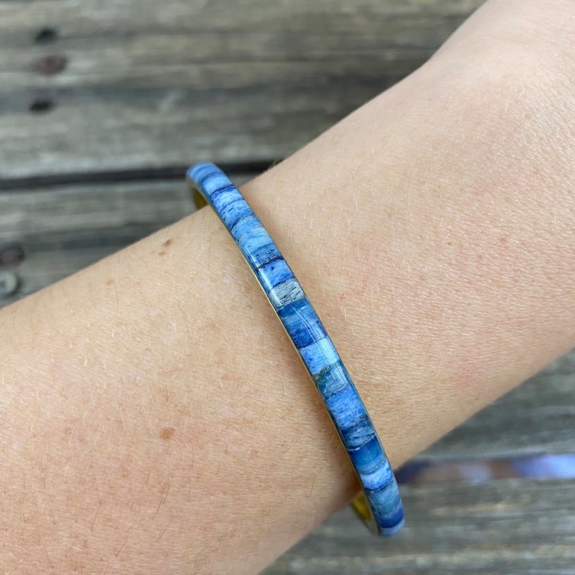 detail of blue resin and metal bangle on modals arm