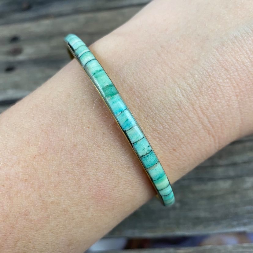 detail of green resin and metal bangle on modals arm