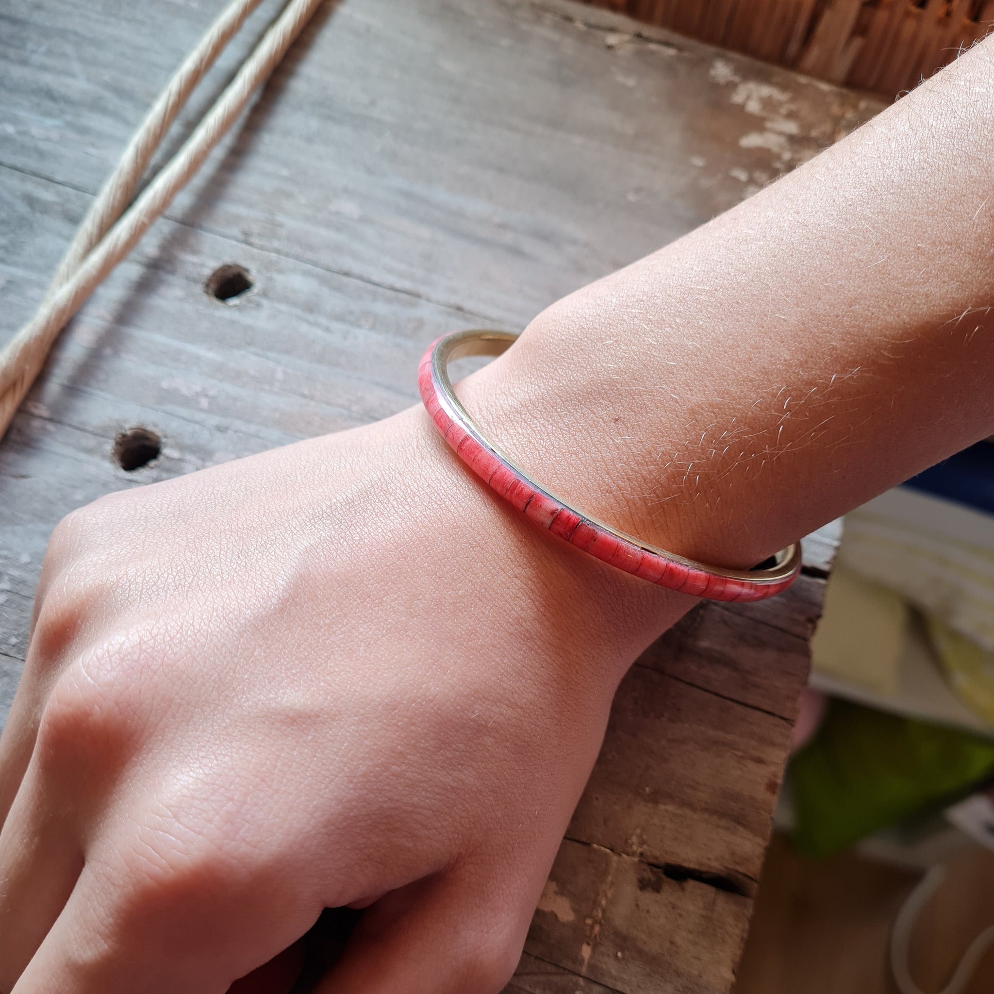 detail of pink resin and metal bangle on modals arm