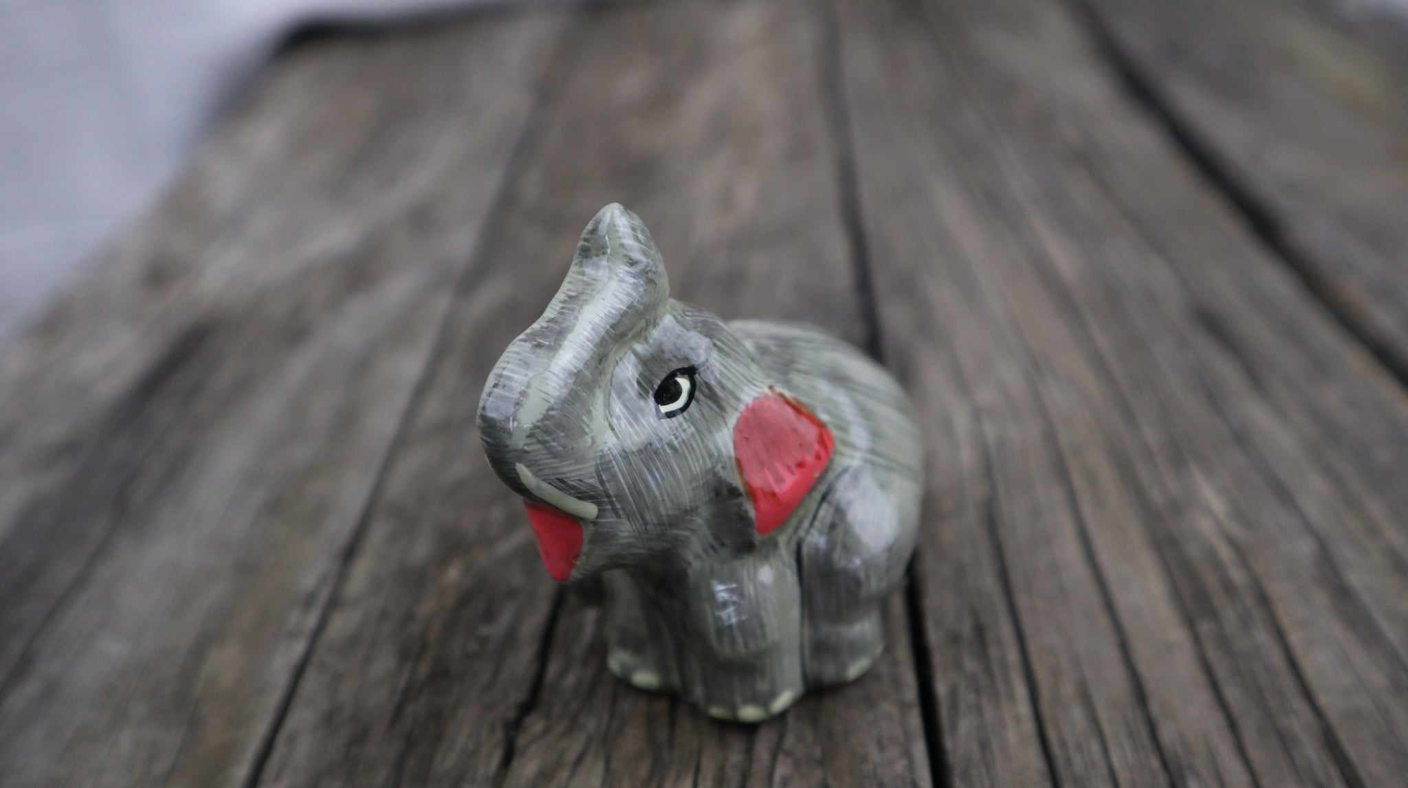Paper Mache baby elephant sitting ornament or decoration. Grey with red mouth and ears