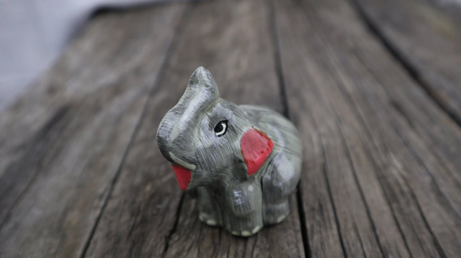 Fair Trade Ethical Sitting Elephant Picture of grey elephant with trunk facing upwards