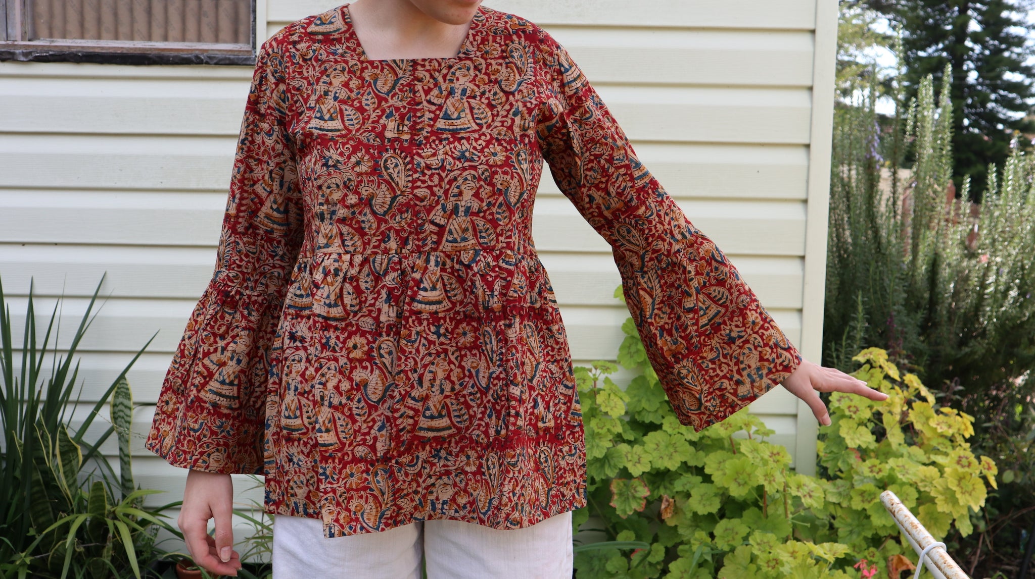 Fair trade ethical bell sleeve top with square neck. Red patterned design with traditional Indian Tanjore Art - women, birds, leaves and flowers are displayed