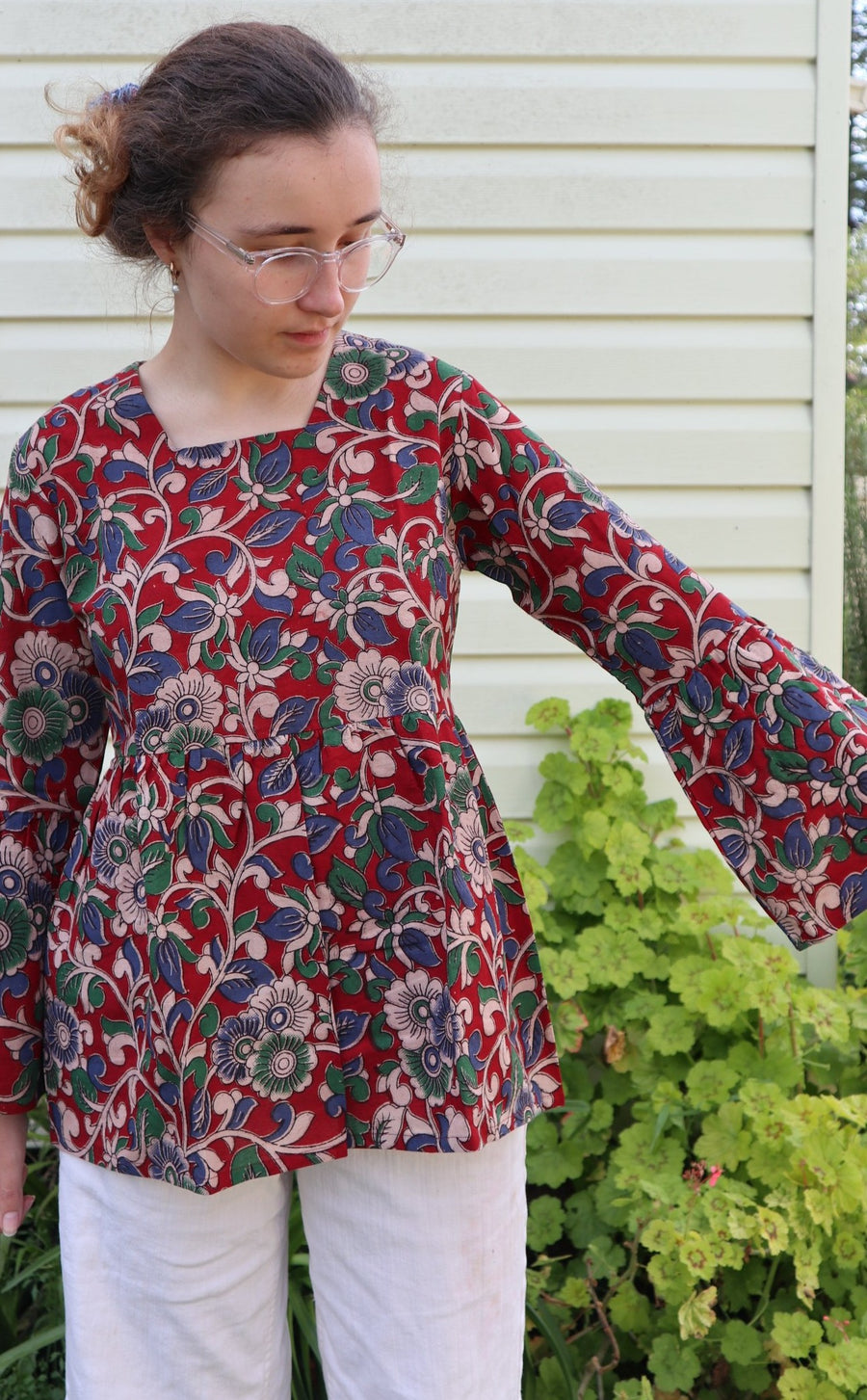 Fair trade ethical bell sleeve top with square neck, Red patterned design with traditional Indian Tanjore Art - vines with various flowers of blue and green colours are displayed 