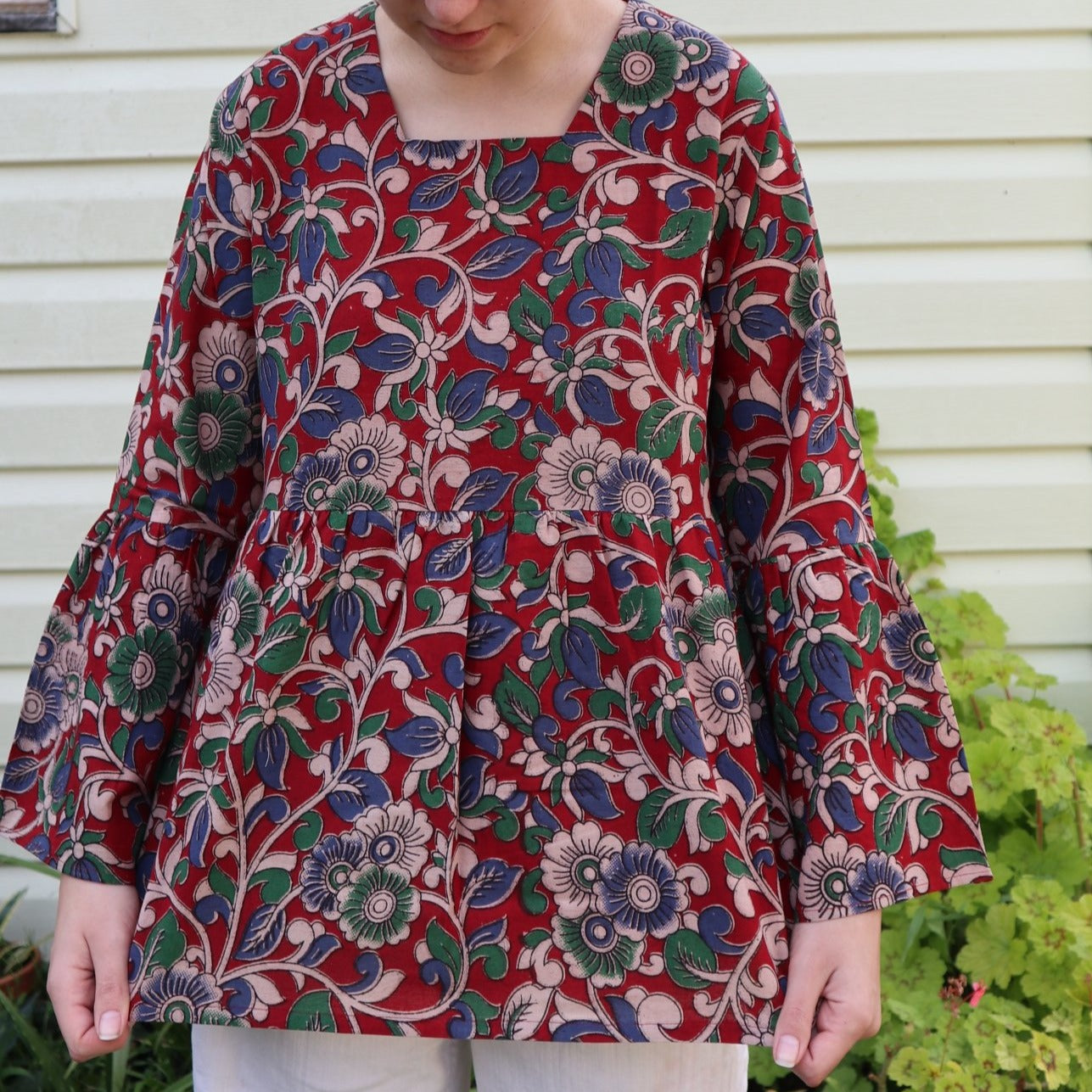 Fair trade ethical bell sleeve top with square neck, Red patterned design with traditional Indian Tanjore Art - vines with various flowers of blue and green colours are displayed