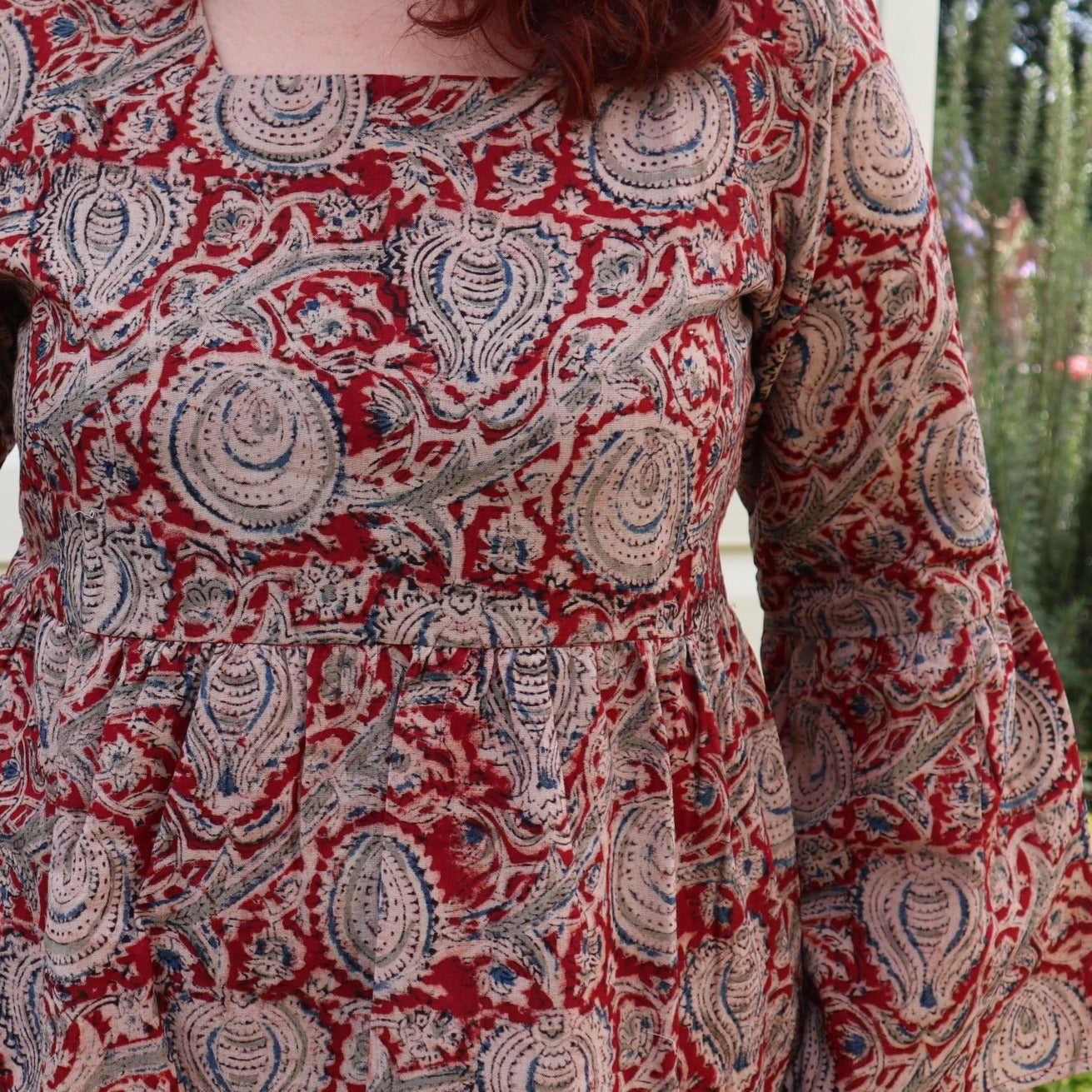 Fair trade ethical bell sleeve top with square neck, Red patterned design with traditional Indian Tanjore Art - branches with abstract fruit and leaves are displayed