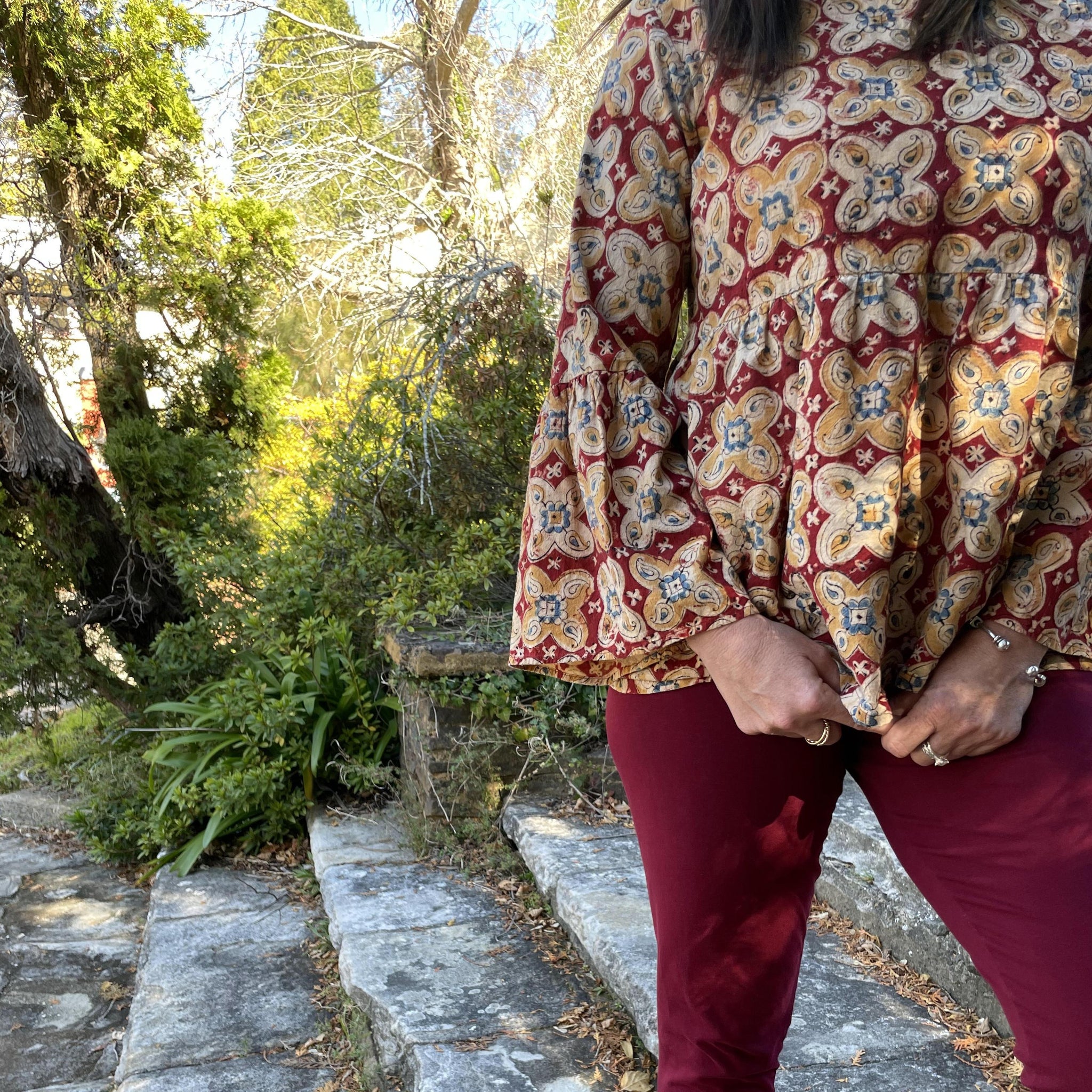 Fair trade ethical bell sleeve top with square neck, a maroon coloured patterned design with traditional Indian Tanjore Art - large flowers of yellow and creme decorate the fabric