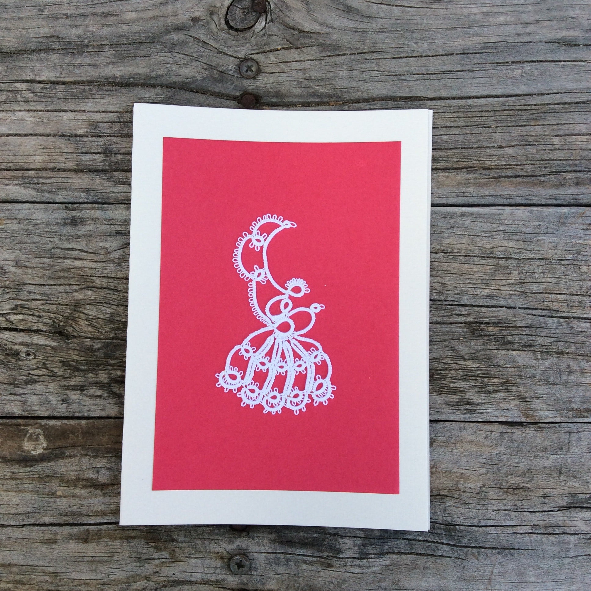 Pink handmade card with a white boarder with a tatted design in the middle.