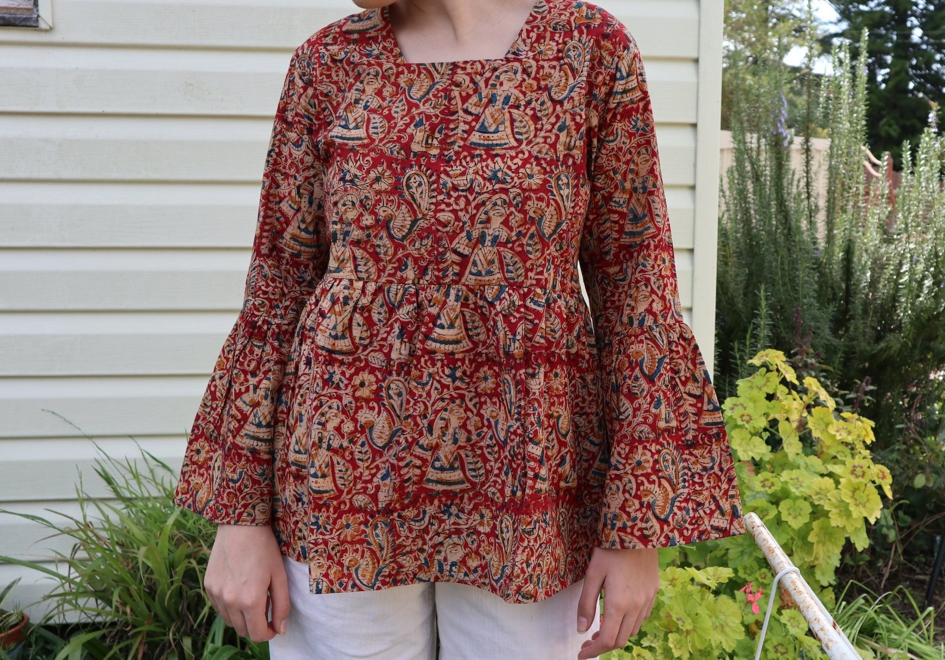 Fair trade ethical bell sleeve top with square neck. Red patterned design with traditional Indian Tanjore Art - women, birds, leaves and flowers are displayed