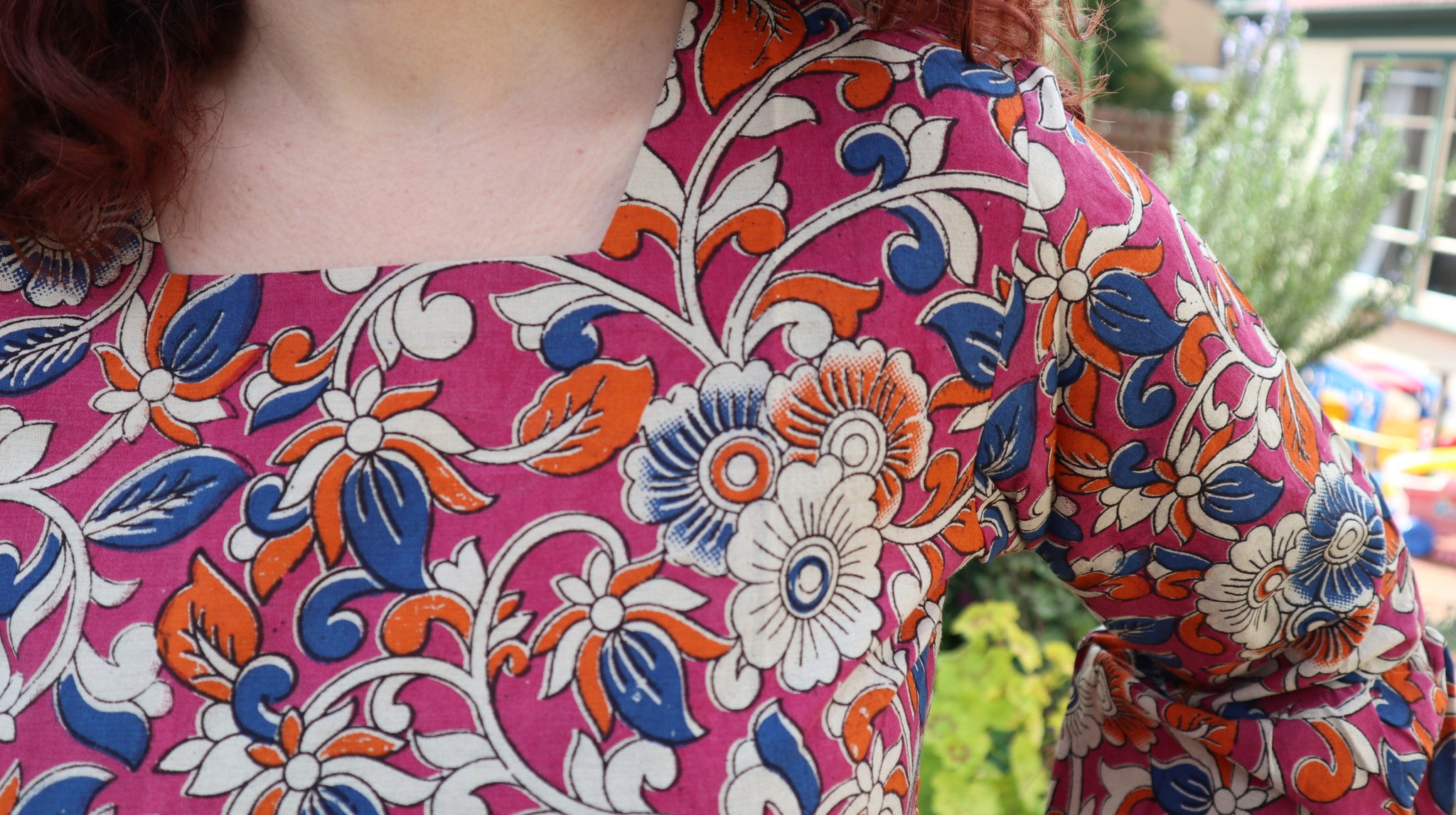 Fair trade ethical bell sleeve top with square neck, an orchid purple patterned design with traditional Indian Tanjore Art - vines with various flowers of blue and orange colours are displayed