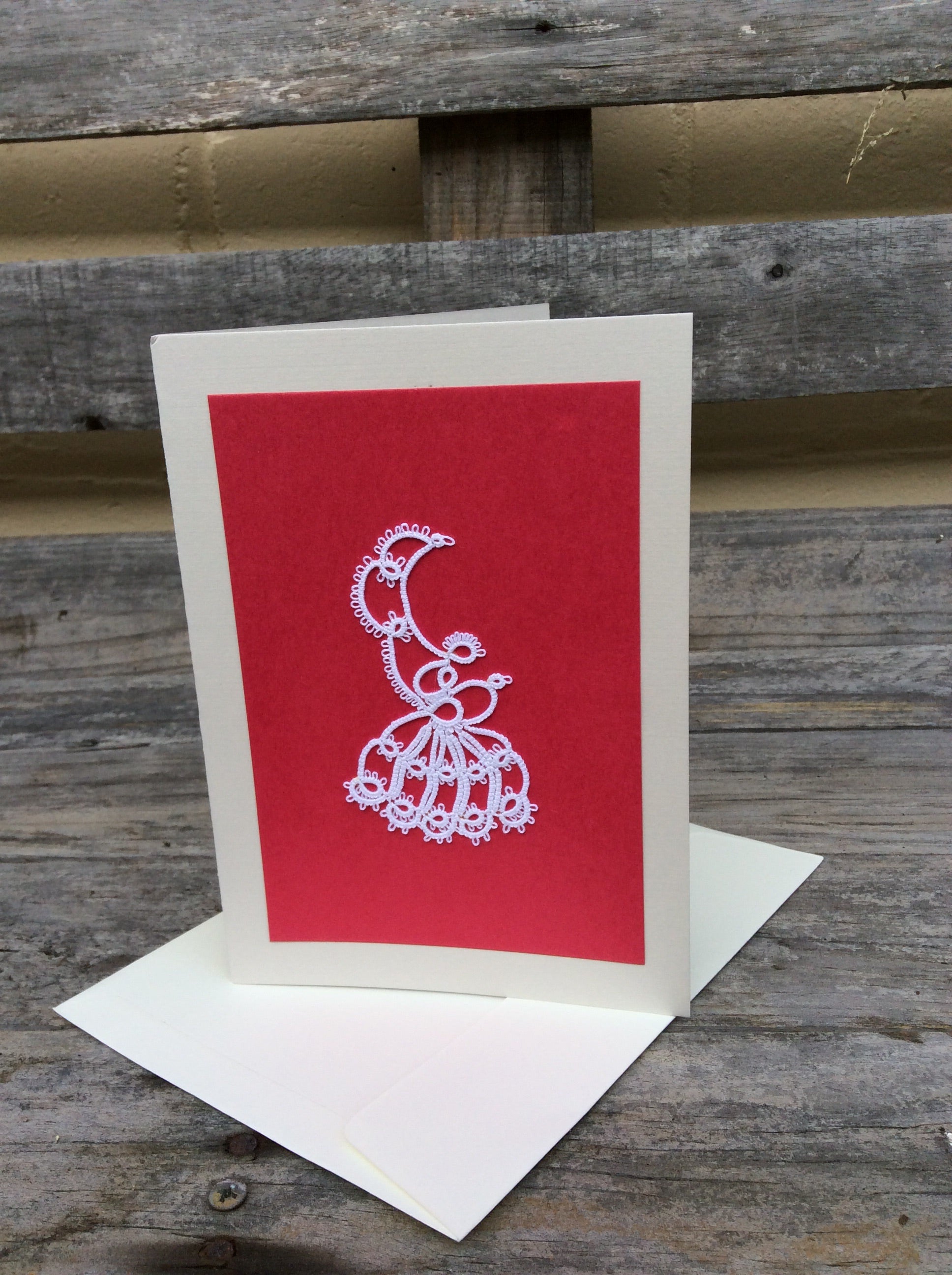 Pink handmade card with a white boarder with a tatted design in the middle.